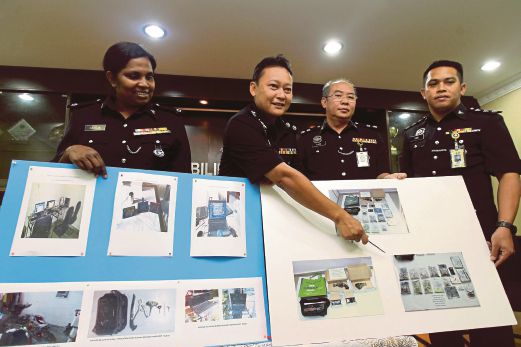 NOR Azman (dua dari kiri) bersama Khoo  (dua dari kanan) serta pegawainya menunjukkan gambar rampasan pistol, dadah dan tablet yang digunakan sebagai judi online pada sidang media di IPK Negeri Sembilan, semalam.