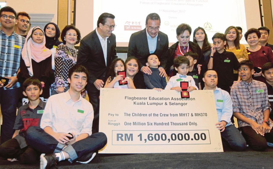 HISHAMMUDDIN dan Liow pada majlis penyerahan cek dana pendidikan kepada waris mangsa MH370.