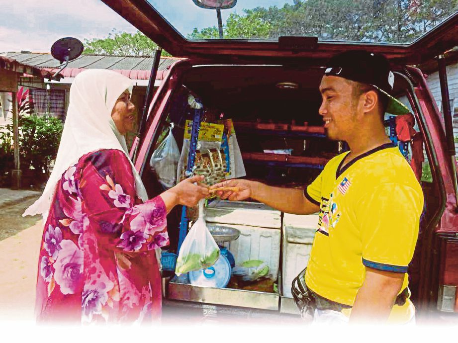 AMIRUL Mukminin (kanan) melayan pelanggan yang membeli barang jualannya. 