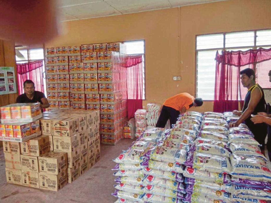 KAKITANGAN JKM Pahang menyusun barangan keperluan harian untuk persiapan banjir.