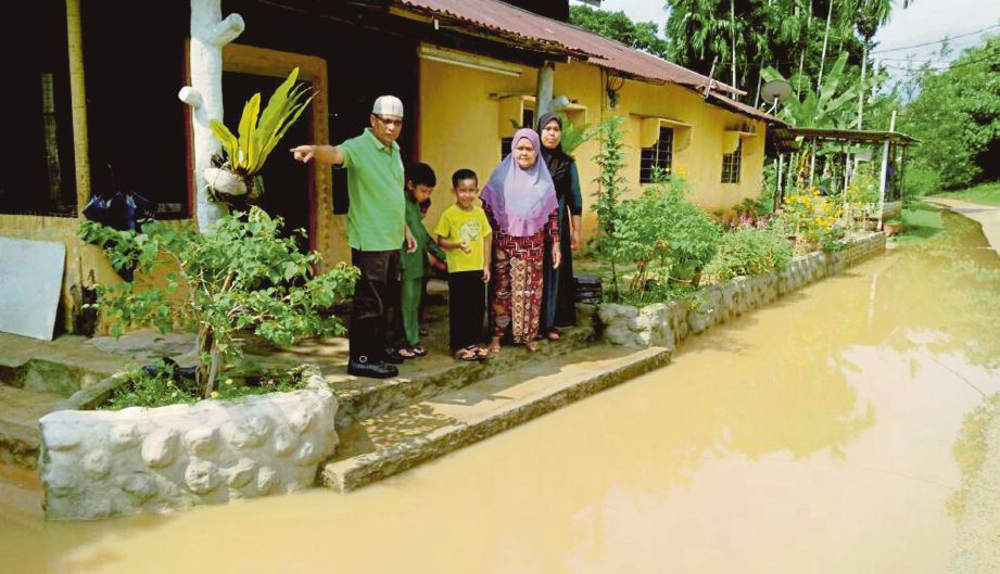  Penduduk menunjukkan  kawasan rumah mereka yang dinaiki air.