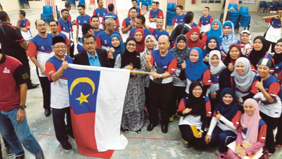 SABARIAH (tengah) menyerahkan bendera negeri kepada kontinjen UiTM Melaka.