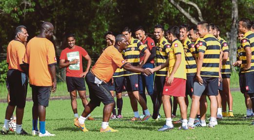 ZAINAL (tengah) bersalam dengan Mohd Azrif Nasrulhaq semasa sesi latihan sebelum bertemu kelab Thailand.