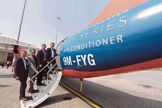 CHENG  (kanan) bersama Ketua Pegawai Eksekutif Firefly Airlines, Ignatius Ong (dua dari kanan) bersama pesawat Firefly Airlines yang dihiasi iklan Panasonic Sky Series, semalam. 