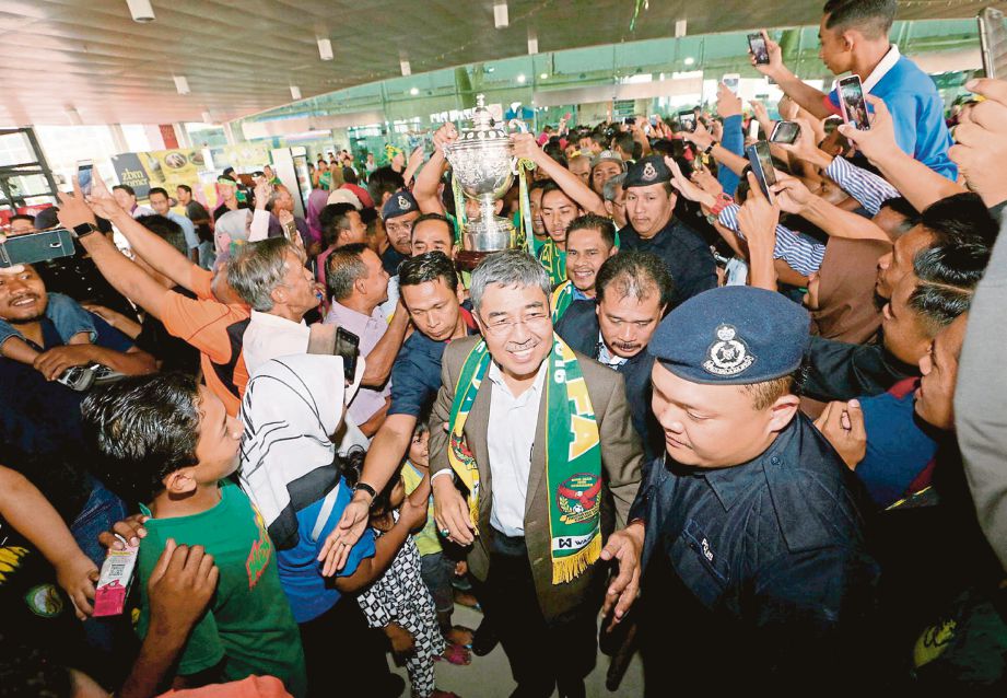 AHMAD Bashah  (tengah) ketika menyambut kepulangan pemain  dan pengurusan pasukan Kedah di  Balai Ketibaan Lapangan Terbang Sultan Abdul Halim, semalam.
