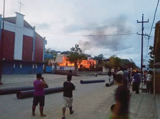 Penduduk melihat kebakaran di rumah Menteri Kesihatan Manipur Phungzaphang Tonsimg.
