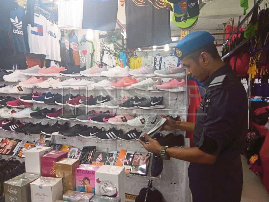   Pegawai   KPDNHEP melakukan rampasan terhadap barangan cetak rompak dijual di Bukit Bintang, semalam. 