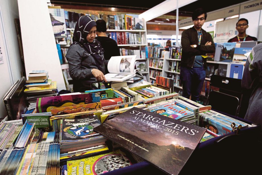 PENGUNJUNG tidak melepaskan peluang untuk memilih buku yang dijual oleh pempamer.