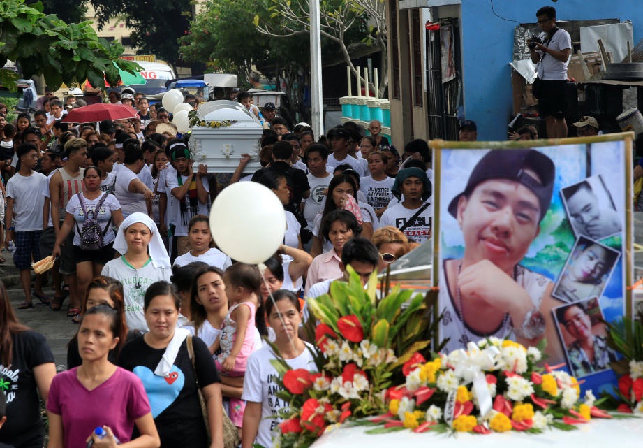 RAKAN dan keluarga John Jezreel David, 21, yang ditembak mati dalam operasi anti dadah polis, mengiringi kerandanya ketika upacara pengebumiannya di Metro, Manila, semalam.  - Reuters 
