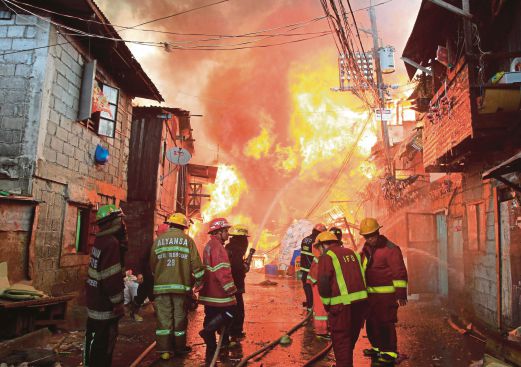 Bomba berusaha memadamkan api yang memusnahkan  2,000 rumah  setinggan. 