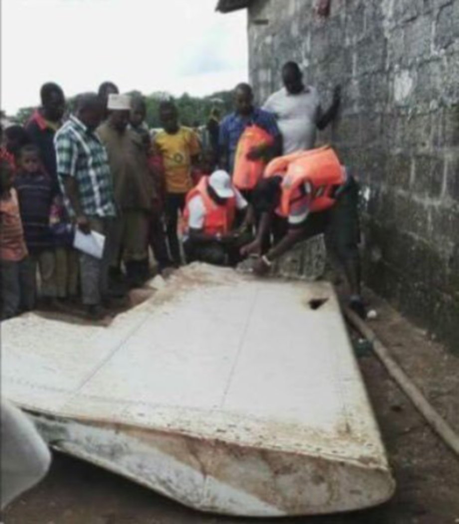 GAMBAR fail menunjukkan pegawai pegawai Tanzania memeriksa serpihan yang dipercayai milik pesawat Penerbangan MH370 di Zanzibar.  