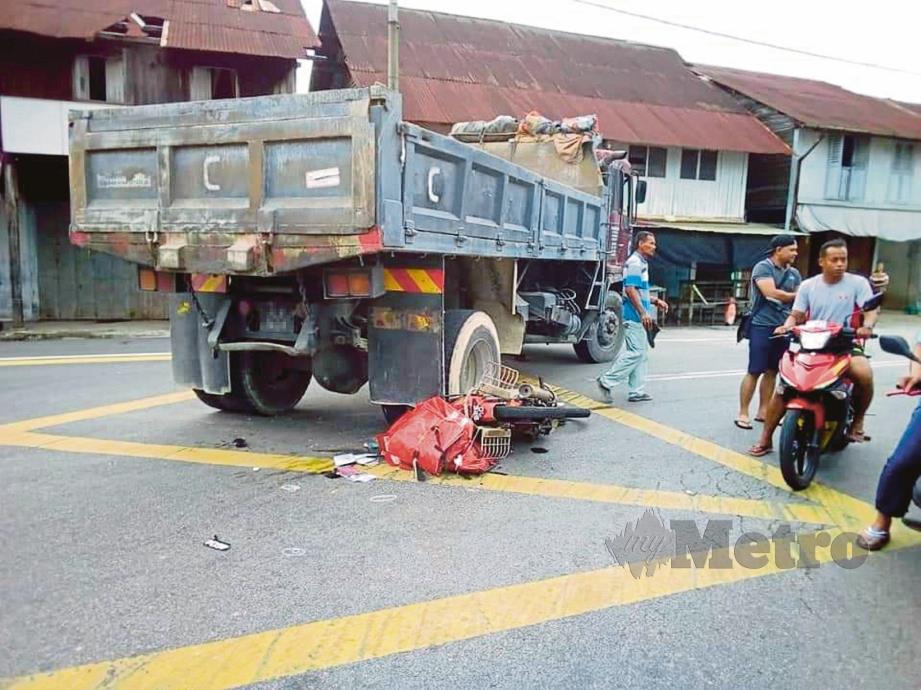 PENDUDUK melihat lori yang melanggar motosikal mangsa di Simpang Tiga Belading, Asahan.