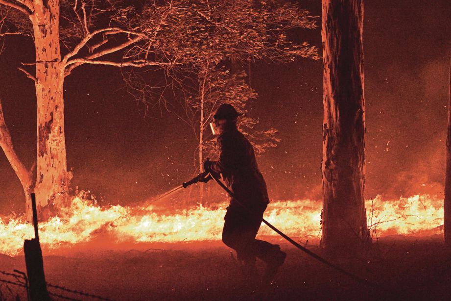 ANGGOTA bomba  memadamkan kebakaran yang  semakin membimbangkan pada malam sambutan Tahun Baru 2020. - Agensi
