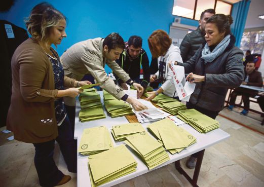 PEGAWAI pilihan raya mengira kertas undi di sebuah pusat mengundi di Istanbul, semalam. 