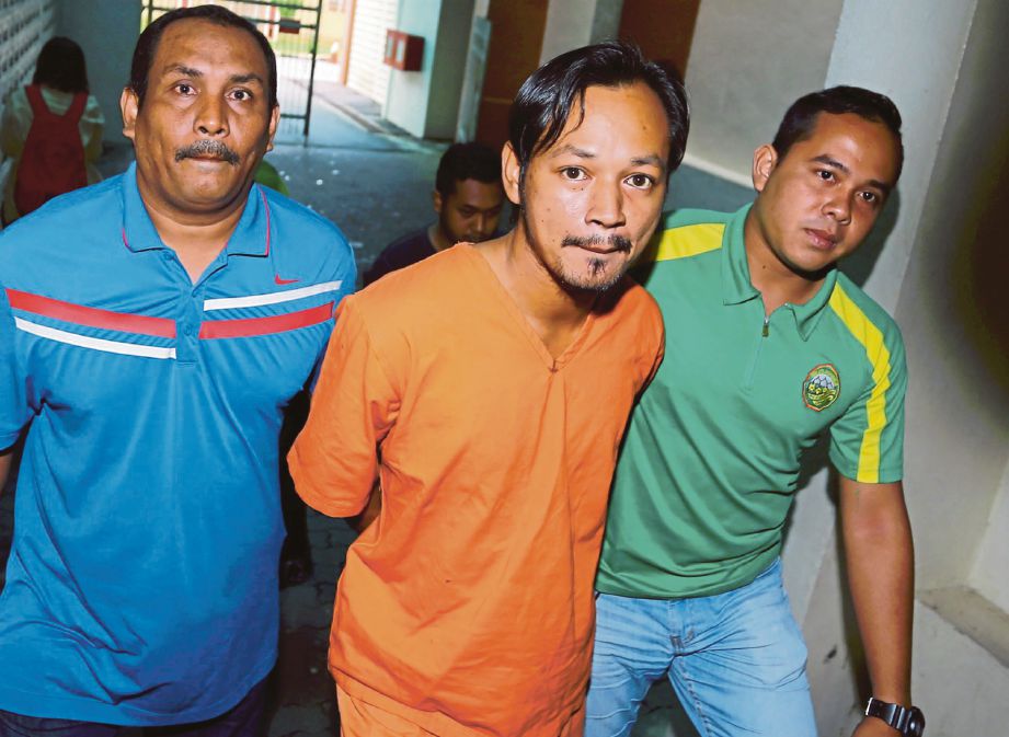 MOHD Hafiz  (tengah) dibawa  polis  untuk sebutan kes di Mahkamah Majistret Kuala Terengganu.