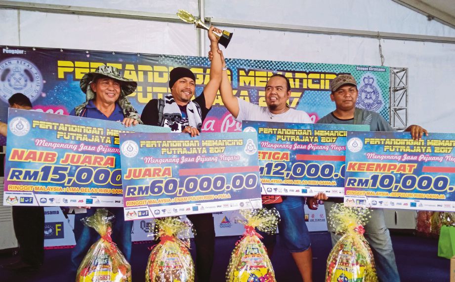 MOHD Fadzil bersama replika cek RM60,000 selepas diumumkan juara Pertandingan Memancing Putrajaya 2017.