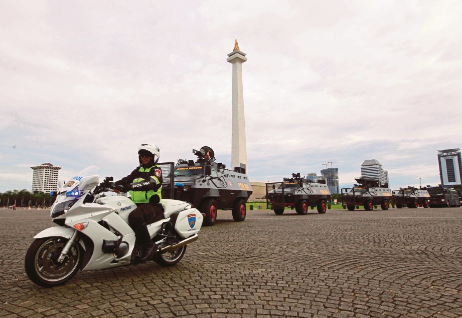 ANGGOTA keselamatan bersedia di pekarangan Monumen Nasional menjelang perhimpunan besar-besaran pada hari ini. - Reuters