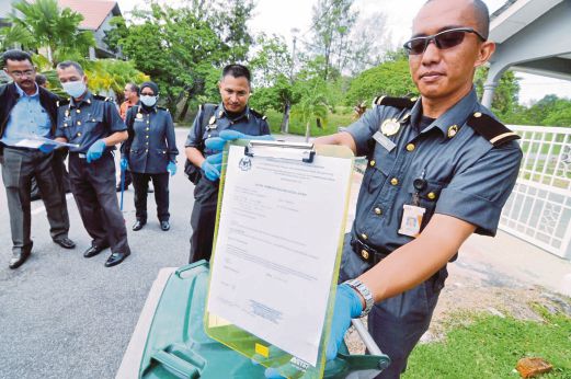 PENGUAT kuasa SWCorp  menunjukkan notis pemberitahuan kesalahan kepada sebuah pemilik rumah yang didapati tidak mengasingkan sisa ketika Operasi Penguatkuasaan Pengasingan Sisa Di Punca (SAS) di Taman Seri Serindit, Bukit Serindit, Melaka. 