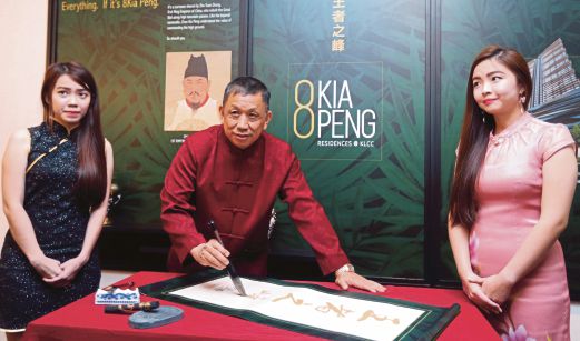 LIM melakukan sentuhan terakhir ke atas kaligrafi Cina ketika majlis perasmian pusat jualan ' 8Kia Peng, King of The Hill'.