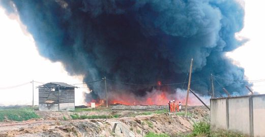 Anggota bomba memadamkan kebakaran  melibatkan kolam simpanan fiber dan tahi minyak  sawit.