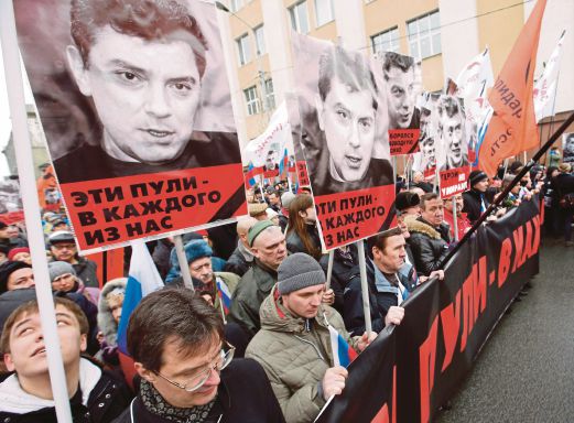 PENYOKONG pembangkang Russia berarak sambil membawa poster gambar Nemtsov di tengah Moscow, semalam.  
