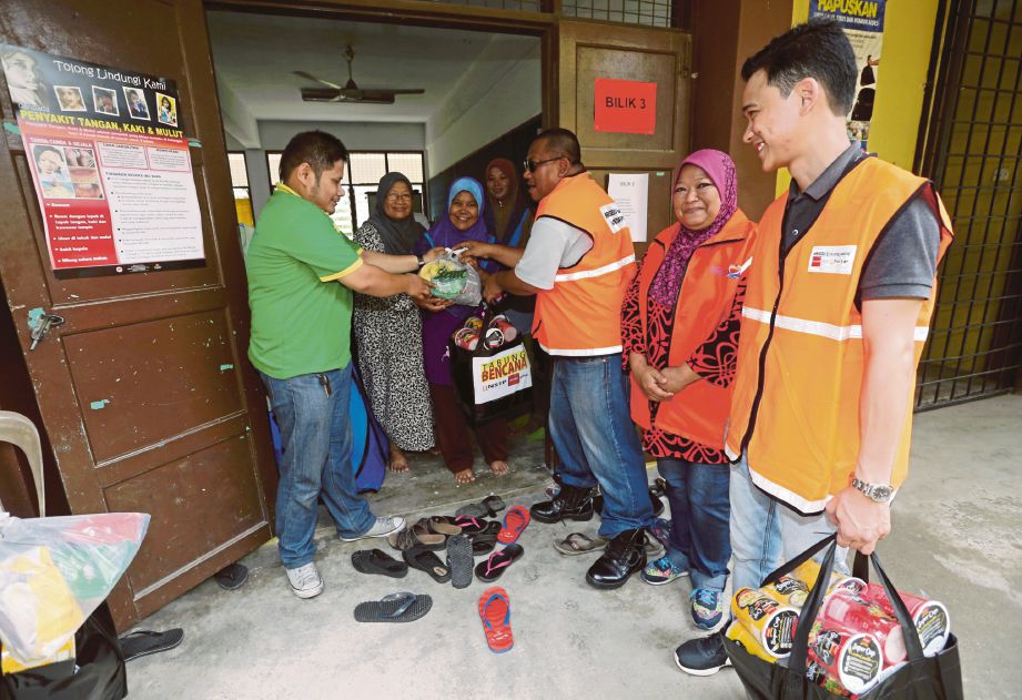  Anggota Briged Sukarelawan Media Prima-NSTP  mengagihkan sumbangan kepada mangsa tanah runtuh.