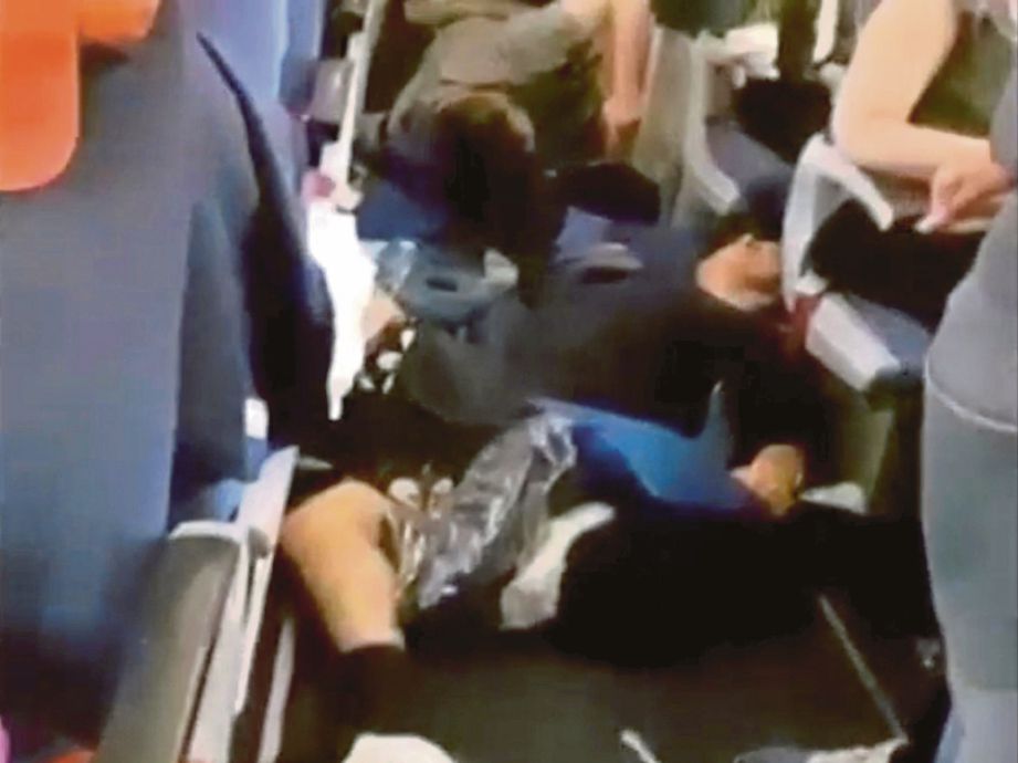 SEDUTAN video menunjukkan beberapa penumpang yang cedera terbaring di lantai pesawat. - Agensi