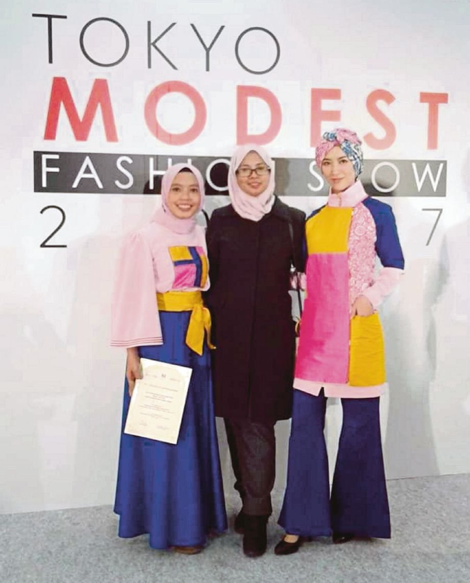 NORAINI (tengah) bersama pelajarnya yang mengikuti pertandingan fesyen.