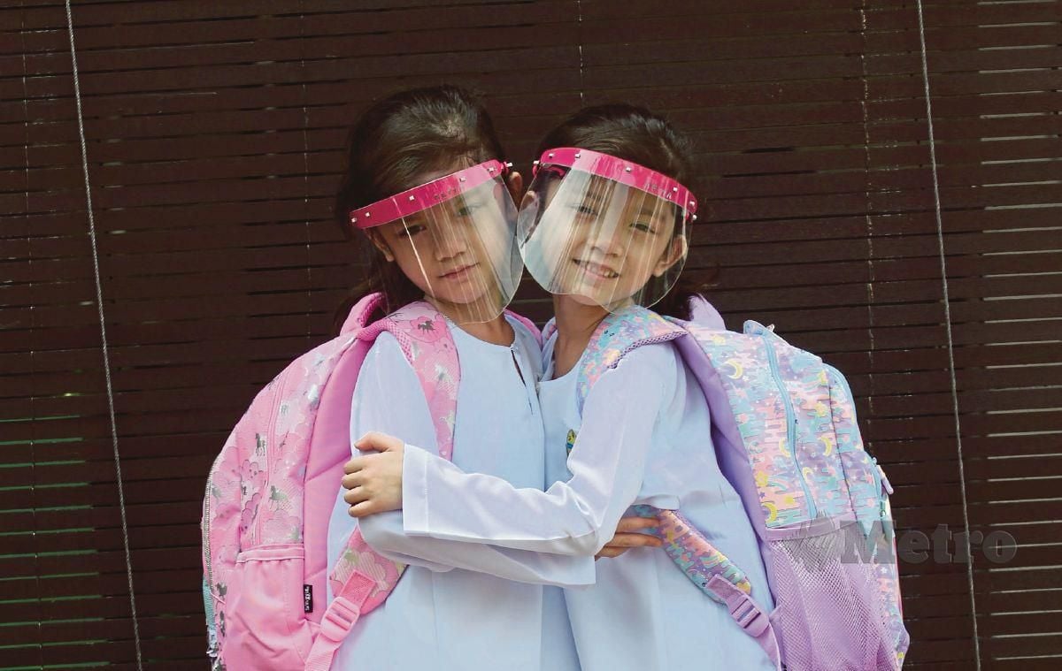 Murid Tahun Satu, pasangan kembar, Nur Dini Aliya Mohd Faiz dan Nur Dini Afiya Mohd Faiz bersiap untuk ke sekolah di kediaman mereka di Putra Heights pada hari pertama sesi persekolahan yang telah dibuka. FOTO EIZAIRI SHAMSUDIN