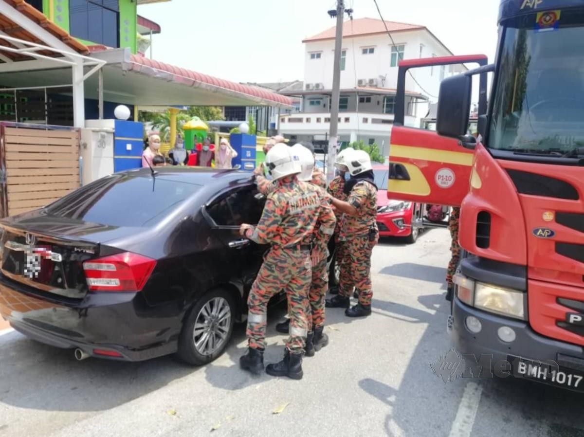Anggota Jabatan Bomba dan Penyelamat Malaysia (JBPM) Pulau Pinang ketika menyelamatkan kanak-kanak perempuan berusia dua tahun yang terperangkap dalam kereta terkunci di Lintang Mayang Pasir di sini. FOTO IHSAN JBPM