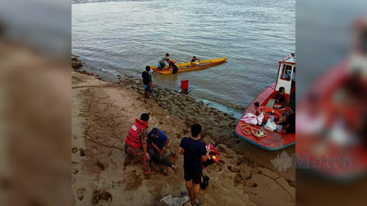 Anggota bomba dan orang awam berada di tempat kejadian bagi membantu mangsa bot karam di Sungai Rajang berhampiran Pekan Kanowit. FOTO MELVIN JONI