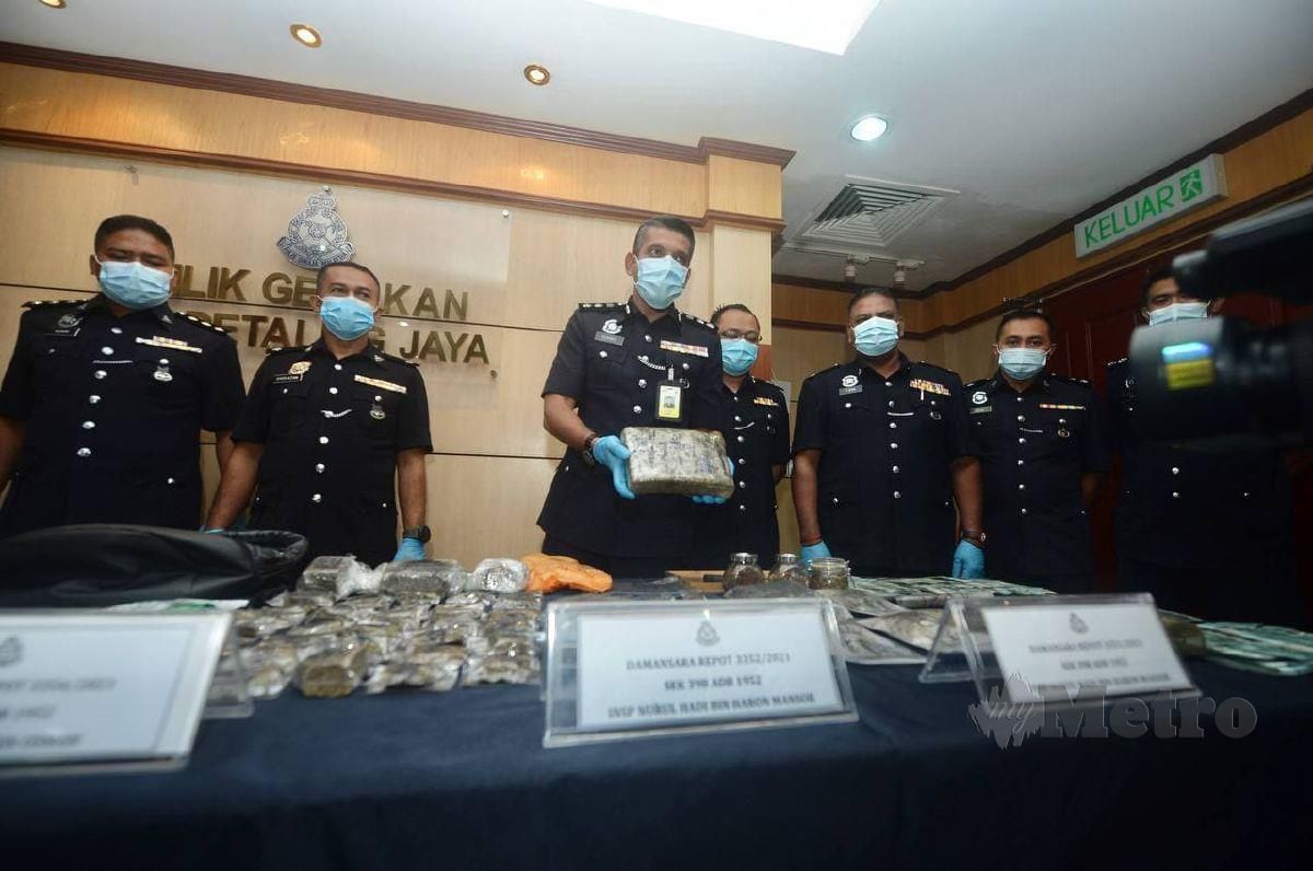 Ketua Polis Daerah Petaling Jaya, ACP Nik Ezanee Mohd Faisal menunjukkan antara barang, wang dan dadah jenis ganja yang dirampas   pada sidang media Jenayah dan Narkotik di IPD daerah Petaling Jaya. FOTO KHAIRUL AZHAR AHMAD
