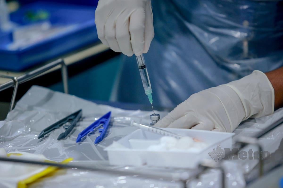 Jururawat membuat penyediaan suntikan vaksin Covid-19 Pfizer-BioNTech sebelum disuntik kepada petugas barisan hadapan. FOTO ASYRAF HAMZAH