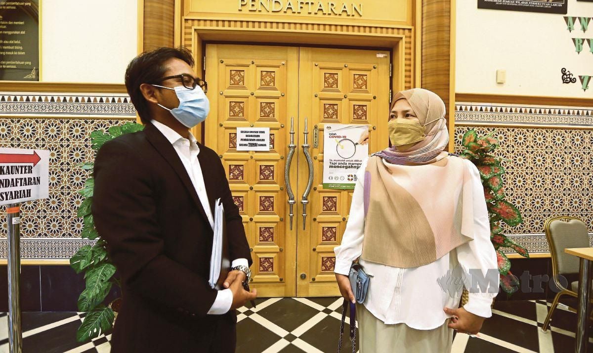 Adibah Abdul Mutalib berbincang bersama peguamnya selepas membuat permohonan hak penjagaan anak di Mahkamah Syariah, Putrajaya. FOTO MOHD FADLI HAMZAH