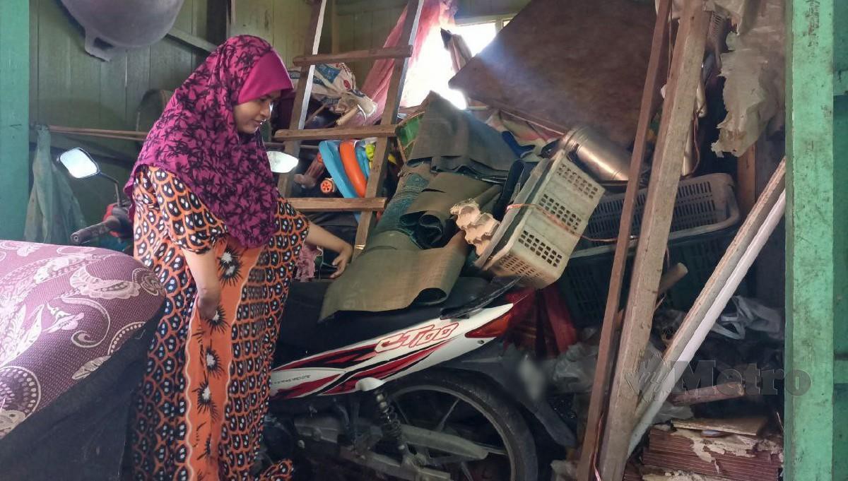 Wanita OKU fizikal, Zauyah Deraman, 37, menunjukkan ruang yang dipenuhi timbunan sisa banjir dan belum sempat dikemaskan lagi di rumahnya di Kampung Ana di sini. FOTO SITI ROHANA IDRIS