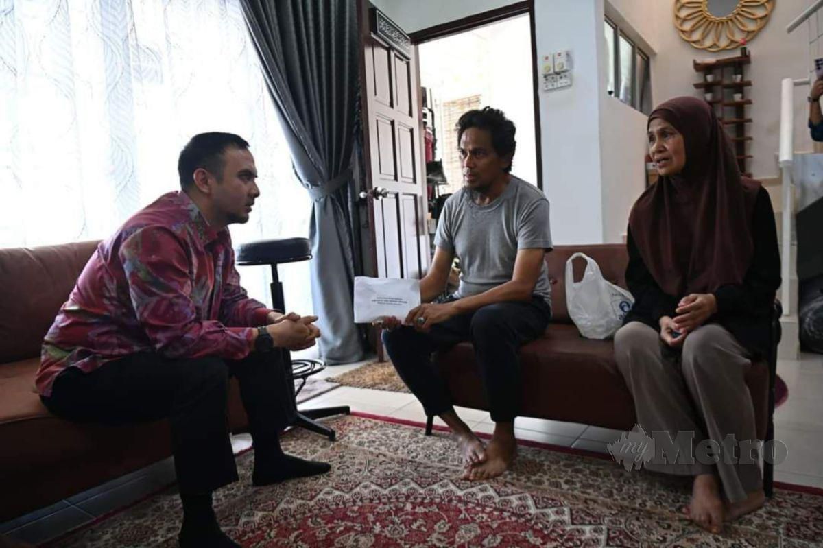 Ahmad Farhan (kiri) berbual dan bertanya khabar kepada Ali yang ditemani isteri.