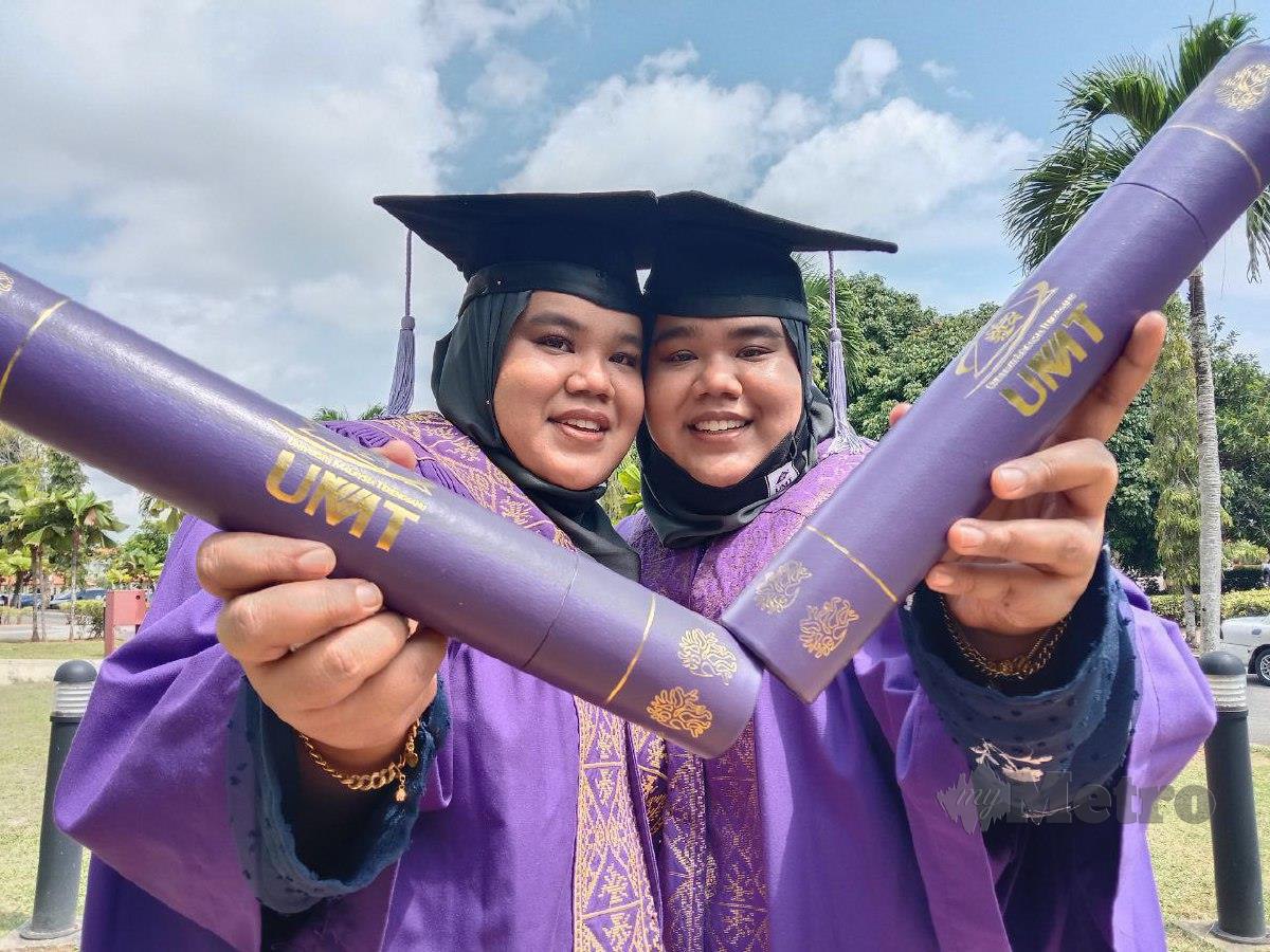 Nur Syakirah Shahrol Aman, 25, (kiri) dan adiknya Nur Shahirah Shahrol Aman, 25, menunjukkan skroll ijazah yang diperolehi di Majlis Konvokesyen Universiti Malaysia Terengganu (UMT). FOTO NAZDY HARUN