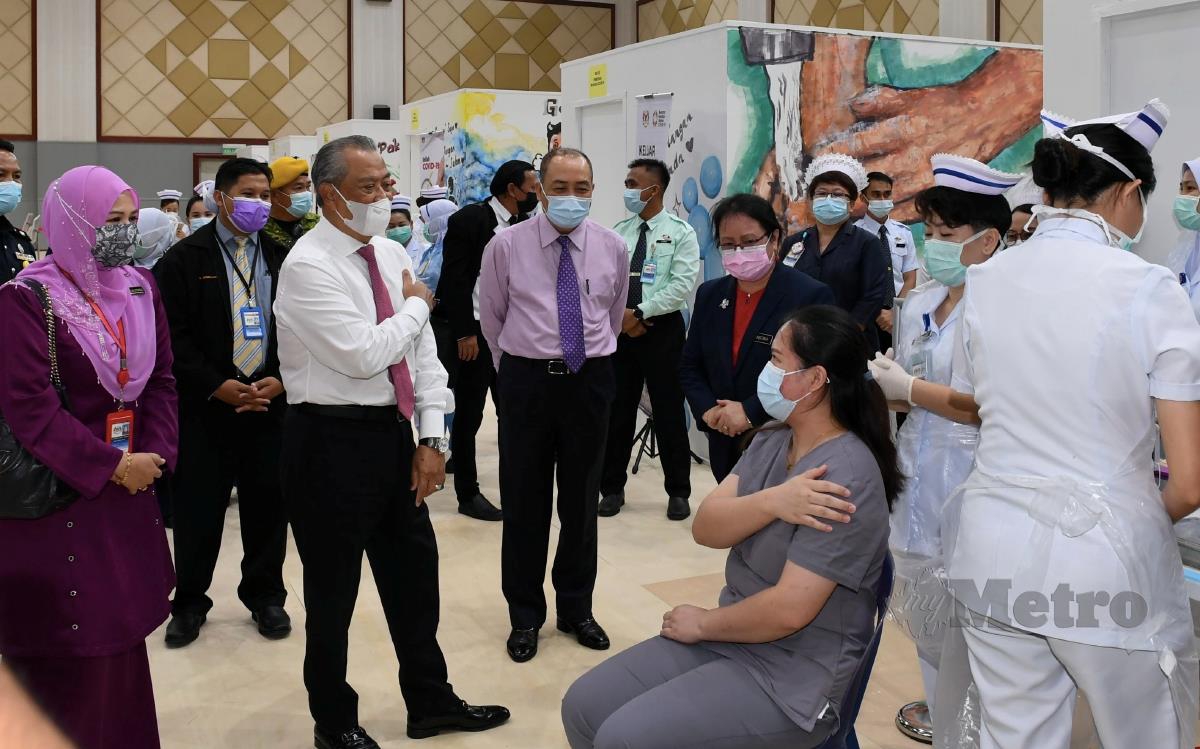 KOTA KINABALU, 22 Mac -- Perdana Menteri Tan Sri Muhyiddin Yassin (tiga, kiri) beramah mesra dengan petugas barisan hadapan yang menerima suntikan vaksin COVID-19 semasa melawat Pusat Vaksinasi COVID-19 Daerah Kota Kinabalu di Kompleks Pentadbiran Kerajaan Persekutuan Sabah hari ini.Turut sama Ketua Menteri Sabah Datuk Hajiji Noor (empat, kiri).-- fotoBERNAMA (2021) HAK CIPTA TERPELIHARA