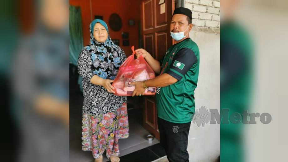 SEORANG daripada ahli jawatankuasa Masjid Tengku Zainal Long, Fadzel Zabidi Zakaria (kanan) mengagihkan kit bantuan kepada anak kariah terjejas sepanjang tempoh Perintah Kawalan Pergerakan di Kampung Air Tawar, Kampung Raja, Besut hari ini. FOTO Nurul Fatihah Sulaini