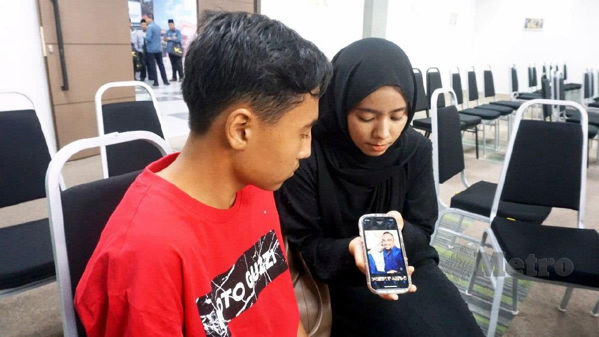 Nurul Fatin Hanani Azmi, 23 bersama adiknya Adam Irfan, 15,  melihat gambar arwah ibu bapa mereka yang maut dalam kemalangan 11 Januari lalu. FOTO Noorazura Abdul Rahman