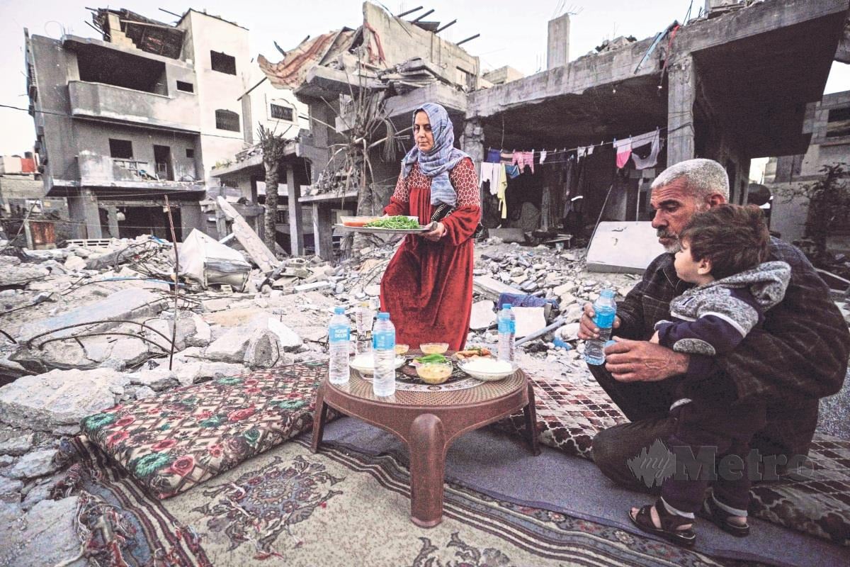 PENDUDUK Palestin berbuka puasa di tengah-tengah runtuhan rumahmereka di tengah Semenanjung Gaza.