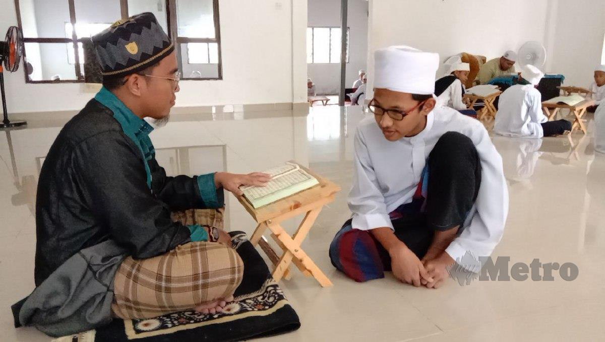 Muhammad Ammar Mohd Khairul Nizam, 17, (baju putih) memperdengarkan bacaan al-Quran kepada gurunya Ahmad Nasrul Hafizul Ismail, 21. FOTO NAZDY HARUN