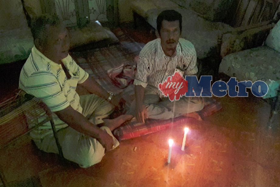 Lelaki OKU, Abu Ni'man Ismail (kanan) dan jirannya Abidin Kamarudin hanya menggunakan caha lilin setiap malam. FOTO Amran Yahya