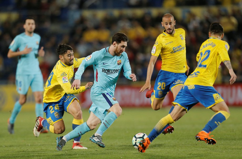 MESSI (tengah) dikekang tiga pemain Las Palmas pada aksi La Liga di Gran Canaria, sebentar tadi. - FOTO REUTERS