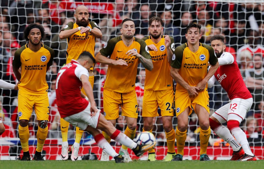PENYERANG Arsenal Alexis Sanchez (kiri) melakukan sepakan percuma ke arah pintu gol Brighton. FOTO/AFP  