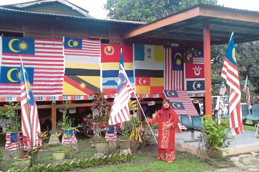 ALIMAH menghias rumahnya dengan lebih 100 Jalur Gemilang dan bendera 13 negeri di Malaysia di kediamannya di Tehel.
