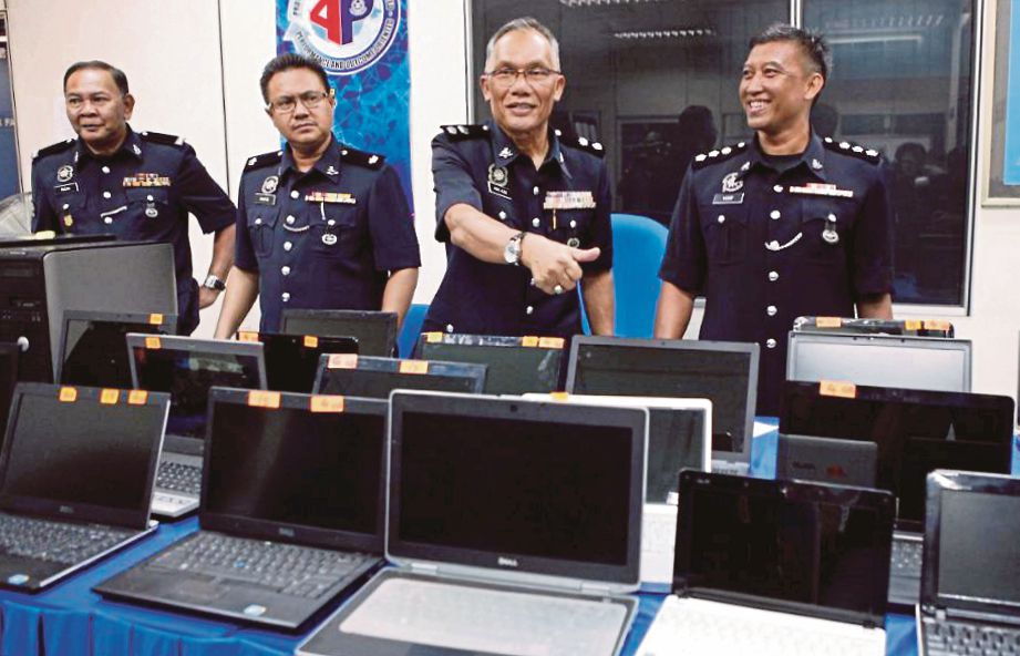 ABD Aziz (dua dari kanan) bersama pegawainya menunjukkan komputer riba, mesin pencetak dan komponen komputer yang dirampas pada sidang media, semalam. 
