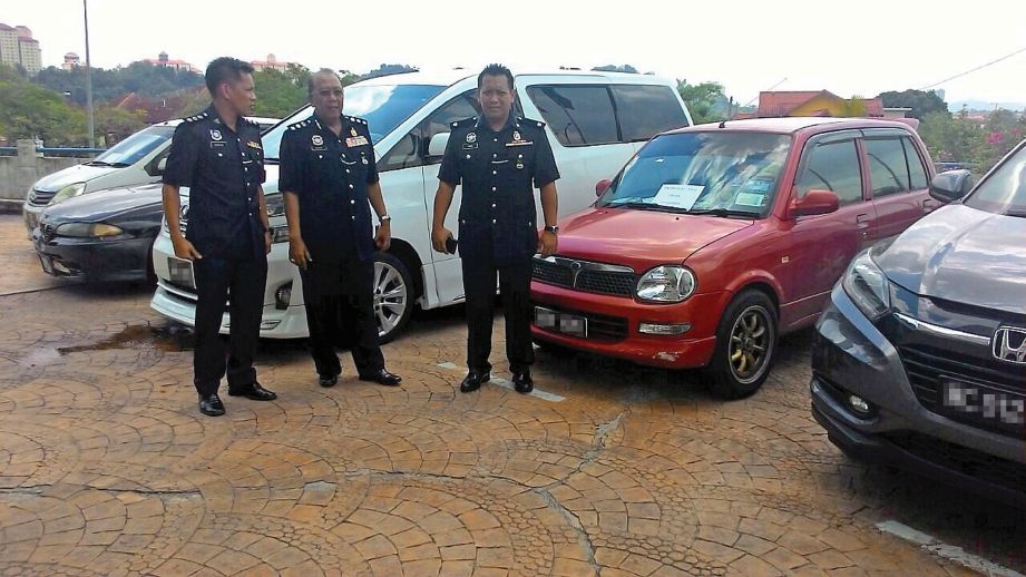 MEGAT Mohamad Aminuddin (tengah) menunjukkan sebahagian kenderaan yang dirampas daripada sindiket.