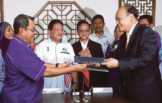 Tengku Adnan menyaksikan Aseh (kiri) bertukar dokumen Perjanjian Pesefahaman dengan Yang (kanan) selepas merasmikan Taman Persahabatan China-Malaysia di Putrajaya.