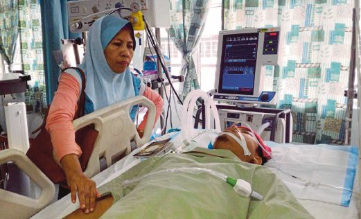 Mariam melihat keadaan Mohammad Afiq  yang kini terlantar dan bergantung kepada mesin sokongan hayat untuk meneruskan hidup di Hospital Melaka. 